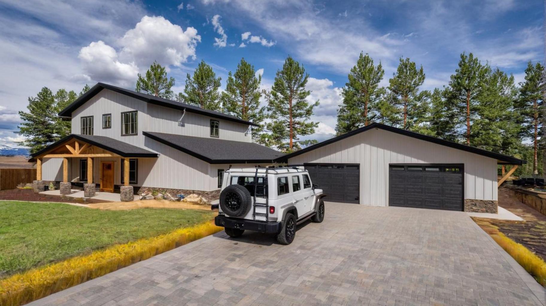 Completed Capitol Peak barndominium build with paver driveway and two-car garage
